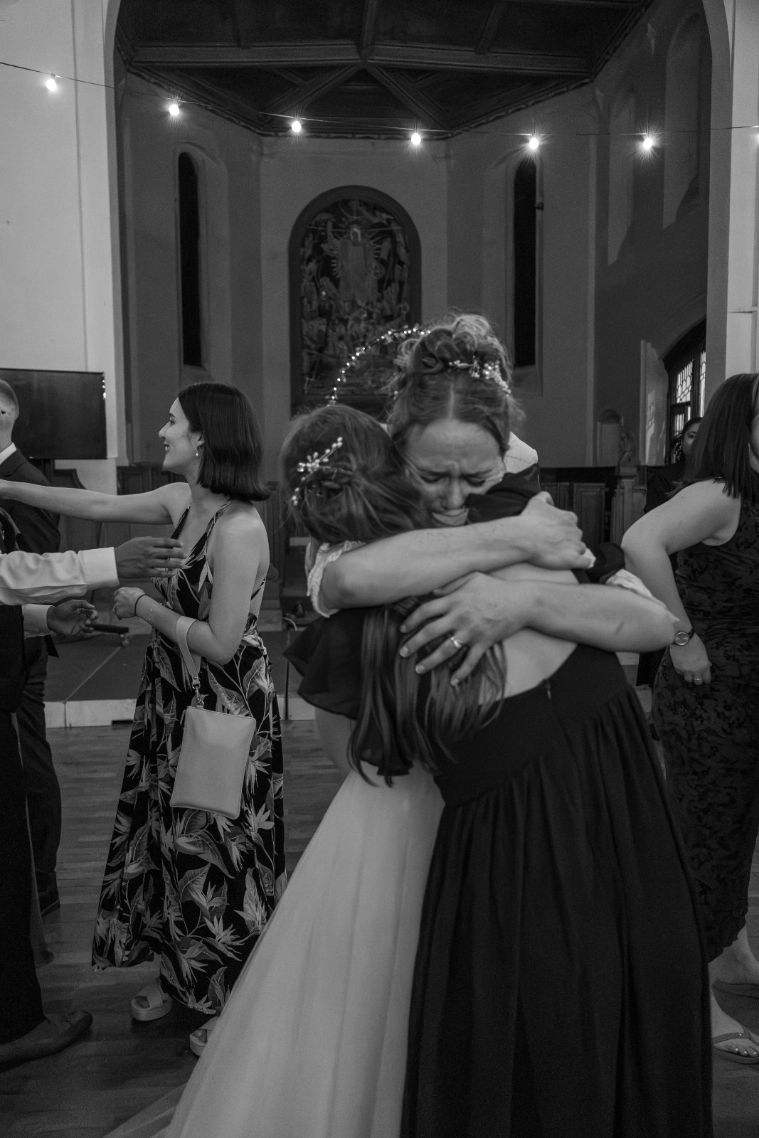 Bride hugging a friend in black and white